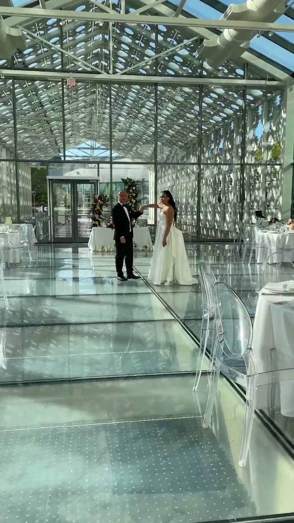 Alex and Jimmy dancing in a glass-walled ballroom at Hotel X Toronto